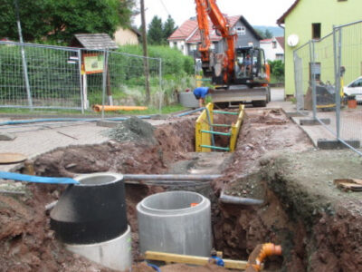Abwasserbeseitigung Ein Bagger setzt neue Abwassersysteme auf einer Baustelle.