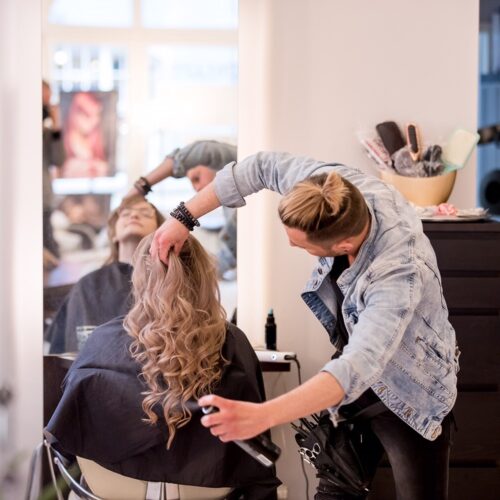 Friseur stylt seine Kundin
