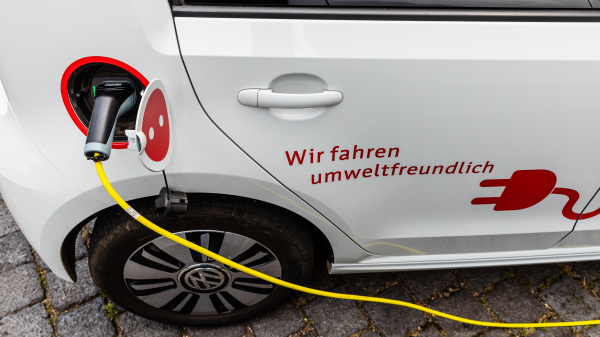 Elektromobilität (im Bild: weißes E-Auto wird geladen, ein Ausschnitt des Autos mit dem Ladekabel ist zu sehen)
