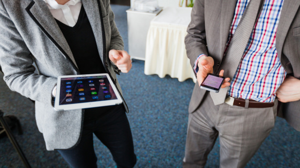 Digitale Veranstaltungen (im Bild: zwei Personen halten jeweils ein Tablet und ein Smartphone)