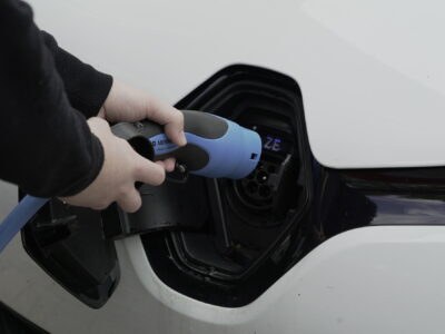 Ein E-Auto wird an eine Ladesäule angeschlossen.