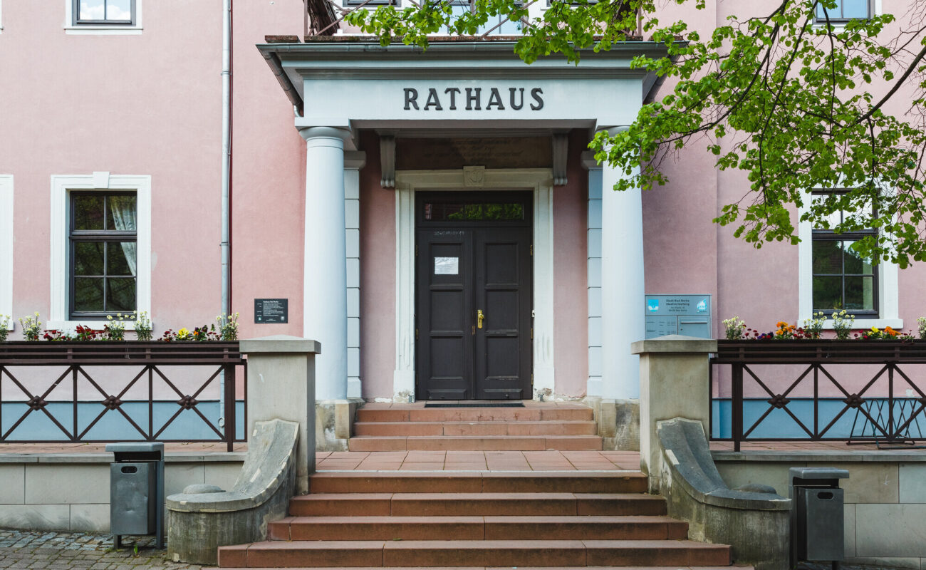 Rathaus in Bad Berka mit pinkem Anstrich und zwei Säulen im Eingangsbereich