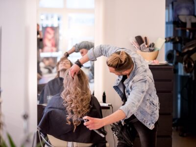 Friseur stylt seine Kundin