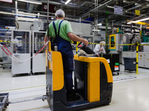 Ein Mann im Blaumann fährt Stapler.