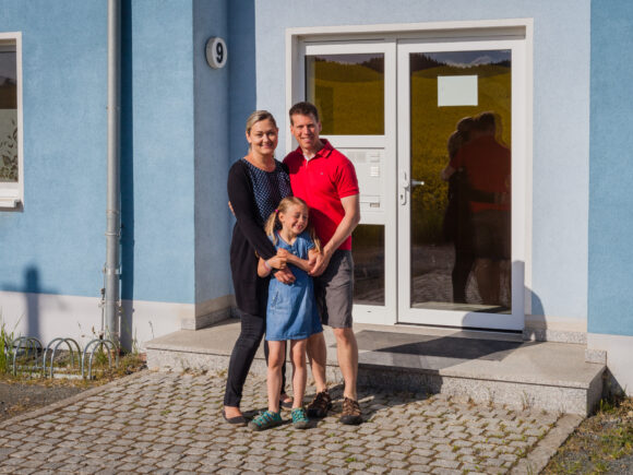 Eine Familie steht vor dem Eigenheim