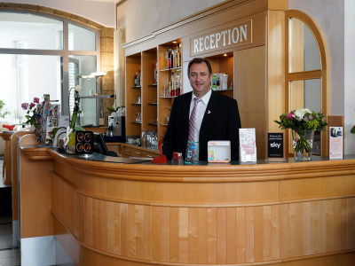 Jan Bachmann ist geschäftsführender Gesellschafter des „Hotels am Kaisersaal“. Einem der insgesamt 7 Hotels des in Erfurt ansässigen Familienunternehmens. (im Bild: Jan Bachmann an der Rezeption)