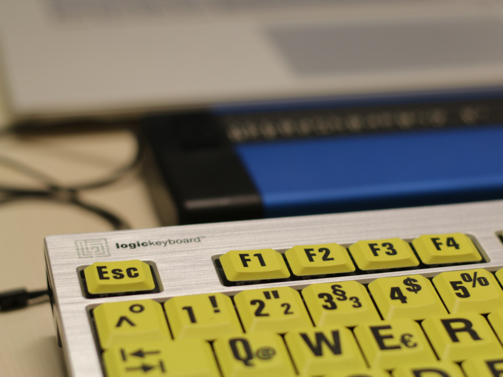 PC-Tastatur mit Braillezeile im Hintergrund