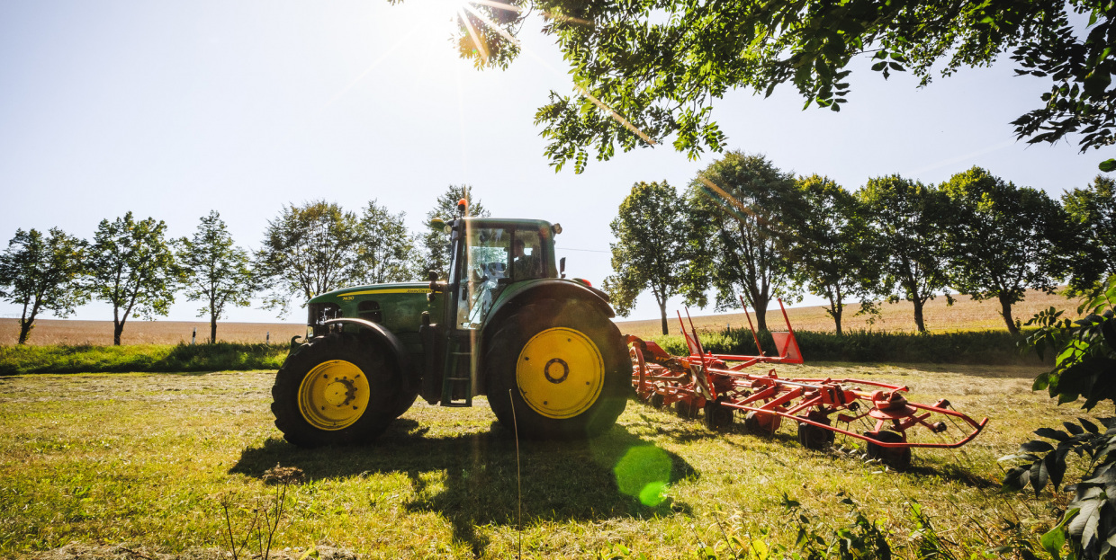 Förderung für Investitionen in die Landwirtschaft (im Bild: Ein Traktor, der über ein Feld fährt)