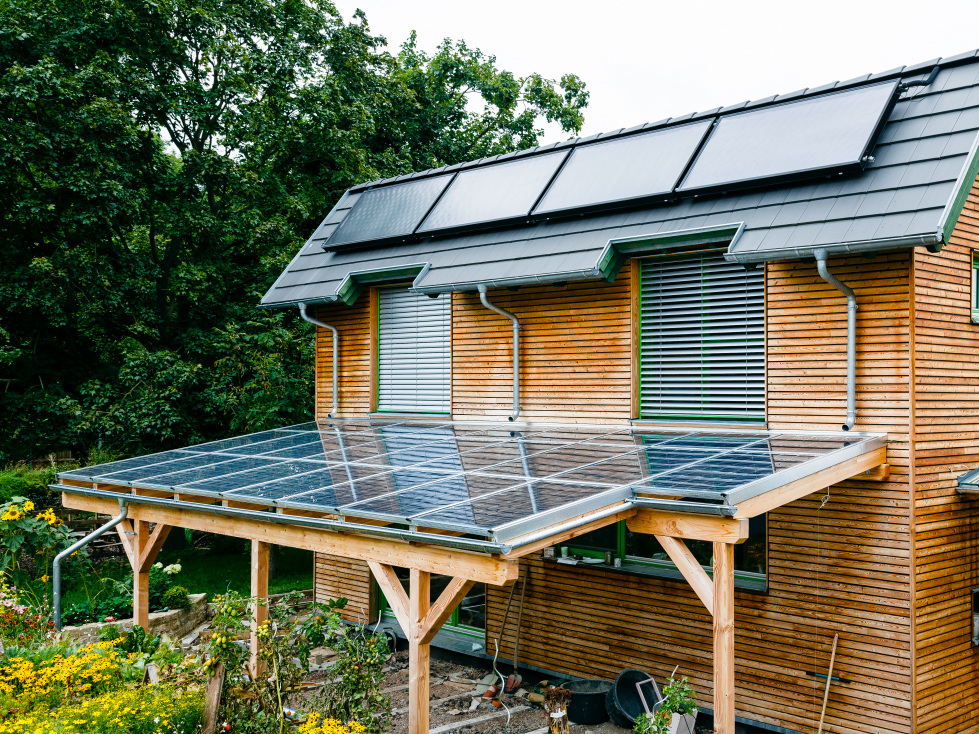Förderung für Solaranlagen in Thüringen. (Im Bild zu sehen: Ein Haus in Holzbauweise mit einer Solaranlage auf dem Vordach und Dach)