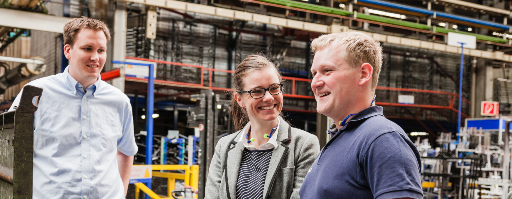 Förderprogramme für Unternehmen in Thüringen (im Bild: ein Gruppe von Menschen in einer Produktionshalle).