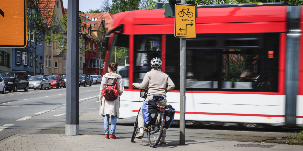 Förderung für Mobilität und Verkehr in Thüringen (im Bild: Radfahrer, Fußgängerin und eine vorbeifahrende Straßenbahn)